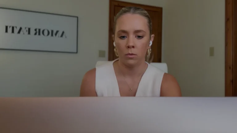 Savannah Abney, a founder personal brand strategist, sitting at a professional desk with a laptop, representing her approach to founder visibility.